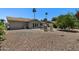 A well-manicured backyard with desert landscaping features a stone area with a patio table and chairs at 932 Leisure World --, Mesa, AZ 85206