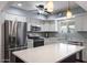 A view of a well-lit kitchen with stainless steel appliances, white cabinets, granite countertops, and modern hanging lights at 932 Leisure World --, Mesa, AZ 85206