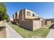 Stucco townhome featuring a well-manicured lawn, courtyard wall, and inviting surroundings at 948 S Alma School Rd # 97, Mesa, AZ 85210