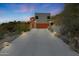 Exterior view of a modern home, showcasing an orange garage door, desert landscaping, and concrete driveway at 9932 N 16Th E Pl, Phoenix, AZ 85020