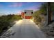 Exterior view of a modern home, showcasing an orange garage door, desert landscaping, and concrete driveway at 9932 N 16Th E Pl, Phoenix, AZ 85020