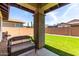 Relaxing covered patio looks out on the home's manicured synthetic lawn at 10059 E Tamery Ave, Mesa, AZ 85212