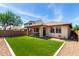 Home boasts a large manicured synthetic lawn, a covered patio, and brick fencing at 10059 E Tamery Ave, Mesa, AZ 85212