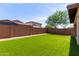 Large backyard features manicured synthetic lawn bordered with gravel and a brick fence at 10059 E Tamery Ave, Mesa, AZ 85212