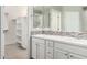 Bathroom with double sinks, a large mirror, and a view into a walk-in closet and tiled shower at 10059 E Tamery Ave, Mesa, AZ 85212