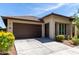 Charming home exterior with a two-car garage, desert landscaping, and a paved driveway on a sunny day at 10059 E Tamery Ave, Mesa, AZ 85212