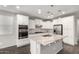 Bright kitchen features stainless steel appliances, granite countertops, white cabinets, and a center island with a sink at 10059 E Tamery Ave, Mesa, AZ 85212