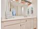 Bright bathroom with a large mirror, towel hooks, and a vanity with white cabinets at 1035 N Vista Verde --, Litchfield Park, AZ 85340