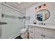 Well-lit bathroom featuring a sleek vanity, round mirror, and a shower with a frosted glass door at 1035 N Vista Verde --, Litchfield Park, AZ 85340