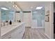 Bathroom featuring double sinks, granite counters, a skylight, and a shower with glass doors at 1035 N Vista Verde --, Litchfield Park, AZ 85340