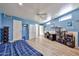 Spacious blue bedroom featuring laminate wood flooring, a ceiling fan, and three closets at 1035 N Vista Verde --, Litchfield Park, AZ 85340