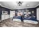 Large shared bedroom with two twin beds, wood-look floors, and a chest of drawers at 10386 N 96Th Pl, Scottsdale, AZ 85258