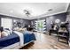 Spacious bedroom featuring dark blue walls, hardwood floors, and a walkout balcony with patio furniture at 10386 N 96Th Pl, Scottsdale, AZ 85258