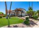 Stunning home with mature trees, stone accents, desert landscaping, and a beautifully manicured front lawn at 10386 N 96Th Pl, Scottsdale, AZ 85258