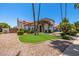 Beautiful home showcasing a lush lawn, mature trees, a stone entryway, and a two-car garage at 10386 N 96Th Pl, Scottsdale, AZ 85258