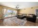 Spacious living room featuring a dark leather sectional, area rug, and sliding doors to the pool at 10386 N 96Th Pl, Scottsdale, AZ 85258