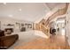Bright living room with fireplace, staircase, hardwood floors, and neutral carpet at 10386 N 96Th Pl, Scottsdale, AZ 85258