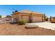 Spacious three-car garage, xeriscaping, beige exterior, and convenient circular fire pit area at 10539 W Tamara Dr, Casa Grande, AZ 85193