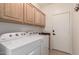 Functional laundry room with washer, dryer, ample cabinet space, and a utility sink at 10539 W Tamara Dr, Casa Grande, AZ 85193