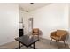 Living room with two tan chairs, a desk, a dark table and a mini refrigerator at 10539 W Tamara Dr, Casa Grande, AZ 85193