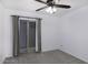 Bedroom with neutral carpet, ceiling fan, and sliding glass door to the outside at 1059 E Broadmor Dr, Tempe, AZ 85282