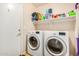 Functional laundry room with white washer and dryer, and a storage shelf at 1060 W Dava Dr, Tempe, AZ 85283