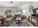Inviting living room with a large sectional sofa, bright window, and a statement clock above the television at 1142 E Mayfield Dr, San Tan Valley, AZ 85143