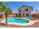 Inviting kidney-shaped pool with tanning ledge, palm tree, and outdoor dining area, perfect for relaxation at 1142 E Mayfield Dr, San Tan Valley, AZ 85143