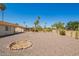 Spacious backyard with gravel landscaping, desert plants, a covered patio and fire pit at 11627 S Iroquois Dr, Phoenix, AZ 85044