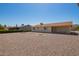 View of the home's backyard with gravel, desert landscaping and a covered patio at 11627 S Iroquois Dr, Phoenix, AZ 85044