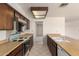 Galley kitchen showcasing wood cabinets, laminate countertops, and standard appliances at 11627 S Iroquois Dr, Phoenix, AZ 85044