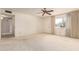 Bright, carpeted living room featuring a ceiling fan, neutral walls, and a window with a view at 11627 S Iroquois Dr, Phoenix, AZ 85044