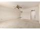 Bright, carpeted living room featuring neutral walls, a ceiling fan, and easy access to the outdoor patio at 11627 S Iroquois Dr, Phoenix, AZ 85044