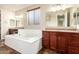Bathroom with a soaking tub, double vanities, and granite countertops at 12029 W Overlin Ln, Avondale, AZ 85323