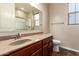 Updated bathroom offers stylish vanity with granite countertop, a mirror and tile flooring at 12029 W Overlin Ln, Avondale, AZ 85323