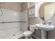 Bright bathroom features a pedestal sink, large mirror and a walk-in shower at 12029 W Overlin Ln, Avondale, AZ 85323