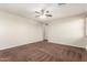 Cozy bedroom with neutral walls, plush carpeting, a ceiling fan, and an ensuite bathroom at 12029 W Overlin Ln, Avondale, AZ 85323