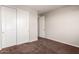 Bedroom includes a closet with sliding doors, soft carpet, and neutral-colored walls at 12029 W Overlin Ln, Avondale, AZ 85323