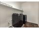 Modern laundry room featuring a dark front-loading washer and dryer set and practical shelving at 12029 W Overlin Ln, Avondale, AZ 85323