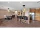 Open-concept kitchen and dining area with a breakfast bar and stainless steel appliances at 14267 W Crocus Dr, Surprise, AZ 85379