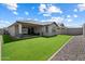 View of the manicured backyard, complete with artificial turf and covered patio seating area at 15070 W Garfield St, Goodyear, AZ 85338