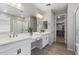 A bright primary bathroom with double sinks, vanity space, glass shower and walk-in closet at 15070 W Garfield St, Goodyear, AZ 85338