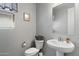 Powder room features a pedestal sink, decorative basket and attractive neutral paint at 15070 W Garfield St, Goodyear, AZ 85338
