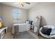 Charming bedroom with a full size bed, chair, mirror and lots of natural light at 15070 W Garfield St, Goodyear, AZ 85338