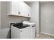 Convenient laundry room with washer, dryer, and upper cabinets at 15070 W Garfield St, Goodyear, AZ 85338