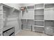 A bright walk-in closet with built-in shelving and hanging rods, for optimal organization at 15070 W Garfield St, Goodyear, AZ 85338
