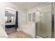 Bright bathroom with a soaking tub, glass shower, and shuttered window, connecting seamlessly to the bedroom at 17562 W Desert Sage Dr, Goodyear, AZ 85338