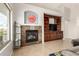 Cozy living room features a tiled fireplace and built-in shelving, perfect for relaxing and entertaining guests at 17562 W Desert Sage Dr, Goodyear, AZ 85338