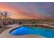 Stunning pool with waterfall feature, lounge chairs, and desert views at 17562 W Desert Sage Dr, Goodyear, AZ 85338