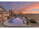 Stunning backyard with a sparkling pool featuring a charming rock waterfall and lush desert landscaping at 17562 W Desert Sage Dr, Goodyear, AZ 85338